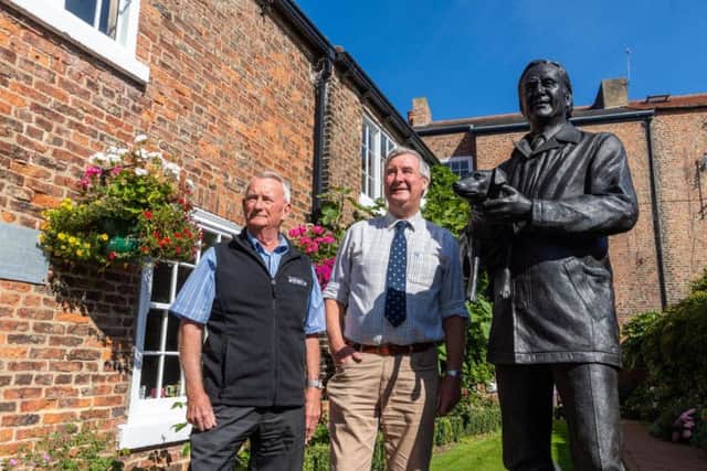 Ian Ashton, managing director of The World of James Herriot, with Peter Wright, from The Yorkshire Vet, pictured with the life-size bronze statue of Alf Wight in the back garden of The World of James Herriot in Thirsk. Picture by James Hardisty.