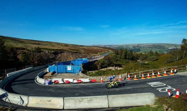 A cyclist climbs out of Swaledale  over the rebuilt bridge, which was washed away the the floods last month, across Grinton Moor on the Elite UCI World Championship Course