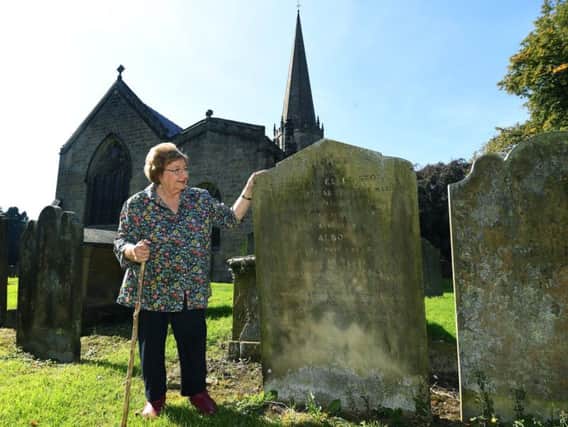 Family historian Denny Gibson has discovered a link between Boris Johnson and Jeremy Corbyn, whose ancestors both lived in Masham in the early 1800s. Pictured in the church yard of The Church of St Mary the Virgin, Masham, looking at a headstone belonging to Thomas and Ellen Stott, the great-great-grandparents of Jeremy Corbyn. Picture: Jonathan Gawthorpe