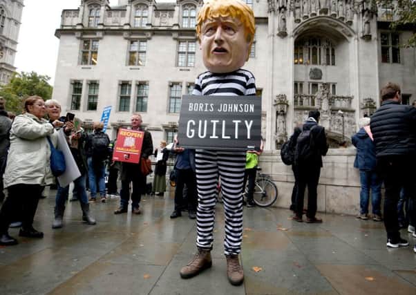 A man wearing a giant Boris Johnson mask, dressed as a prisoner, outside the Supreme Court in London, where judges have ruled that Prime Minister Boris Johnson's advice to the Queen to suspend Parliament for five weeks was unlawful.