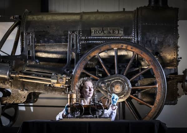 Lead Conservator Wendy Somerville-Woodiwis with Stephenson's Rocket and a model locomotive as she unveils the Rocket's new home, the National Railway Museum in York, where it will be on display until April next year. PA Photo.