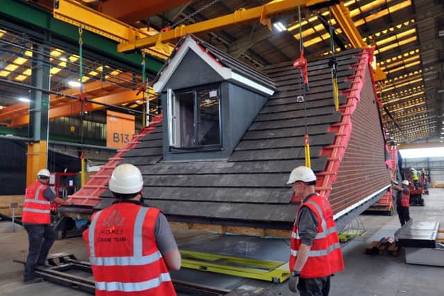 Workers at Ilke Homes' Flaxby factory manoeuvre a roof for a modular home to ready it for transportation. PHOTO: Gary Longbottom.