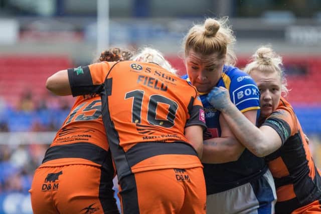 Powering through: Rhinos' Danika Prim is tackled by Castleford's Grace Field and Georgia Roche.