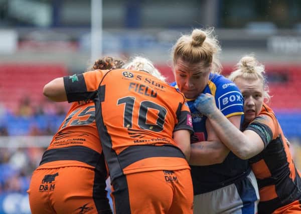 Powering through: Rhinos' Danika Prim is tackled by Castleford's Grace Field and Georgia Roche.