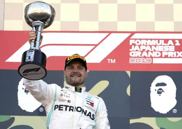 Winner: Mercedes driver Valtteri Bottas raises his trophy on the podium after winning the Japanese Grand Prix at Suzuka.