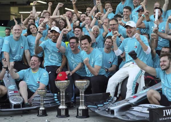 Champions: Winner Valtteri Bottas, right in white cap, and third-placed Lewis Hamilton , left in white cap, celebrate with Mercedes crew.
