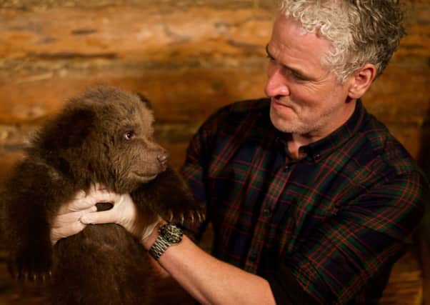 Gordon Buchanan holding bear cub. (Photo credit:  Anwar Mamon).
