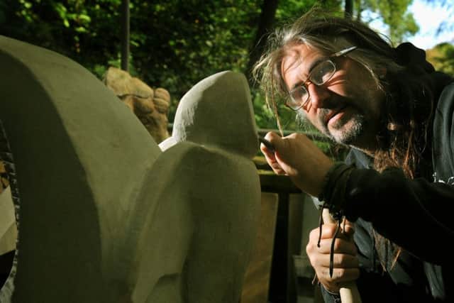 Andrew Vickers  of Stoneface Creative , working on an owl  stone sculpture in the woods at Storrs  in South Yorkshire .