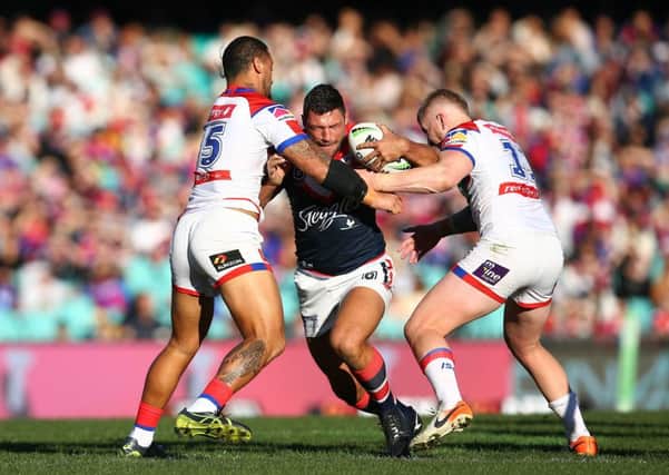 TOUGH GOING: Sydney Roosters' Ryan Hall of the Roosters is tackled by Newcastle Knights' James Gavet and Mitchell Barnett  in July this nyear. Picture: Jason McCawley/Getty Images