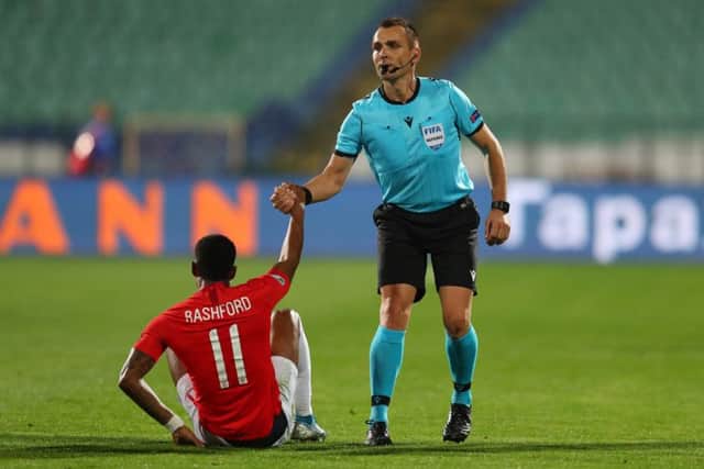 CRITICISM: Referee Ivan Bebek helps up Marcus Rashford in Sofia on Monday night. Picture: Catherine Ivill/Getty Images