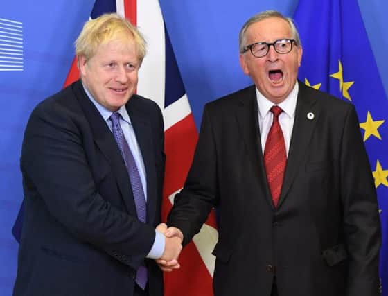Boris Johnson and Jean-Claude Juncker shake hands after reaching a Brexit deal.