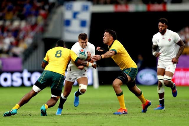 England's Henry Slade (second left) is tackled by Australia's Isi Naisarani (left) and Rory Arnold at Oita Stadium. Picture: David Davies/PA