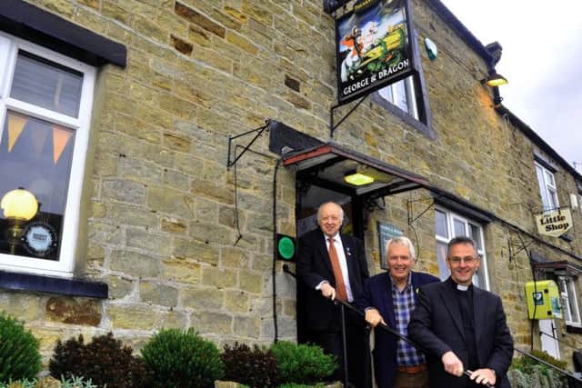 (Left to right) Coun Carl Les, leader of North Yorkshire County Council, community worker Martin Booth, and the Reverend John Dobson, Dean of Ripon Cathedral, on the steps of the George and Dragon community owned pub at Hudswell near Richmond. Picture by Gary Longbottom.