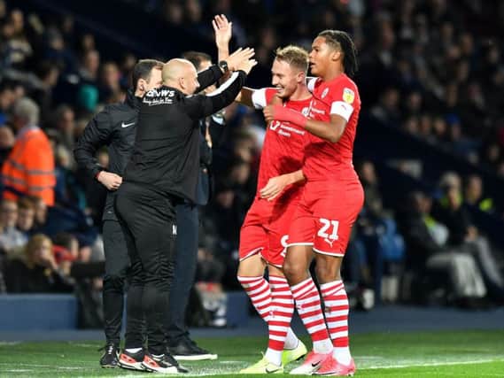 Cauley Woodrow celebrates his second goal at West Brom with Toby Sibbick and Barnsley caretaker manager Adam Murray.