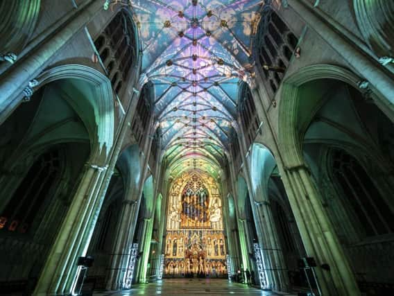 A woman looks on as an art installation is projected on to the interior of York Minster ahead of their Northern Lights opening. 
PA Photo.