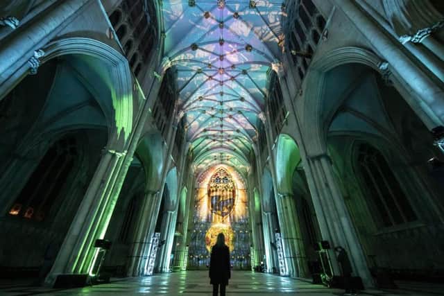 A woman looks on as an art installation is projected on to the interior of York Minster ahead of their Northern Lights opening. 
PA Photo.
