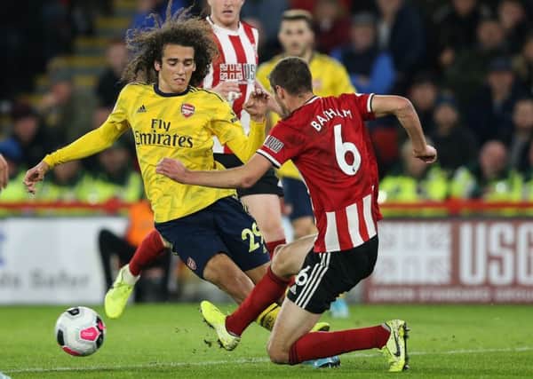 In the thick of it: Chris Basham tackles Arsenal's Matteo Guendouzi.