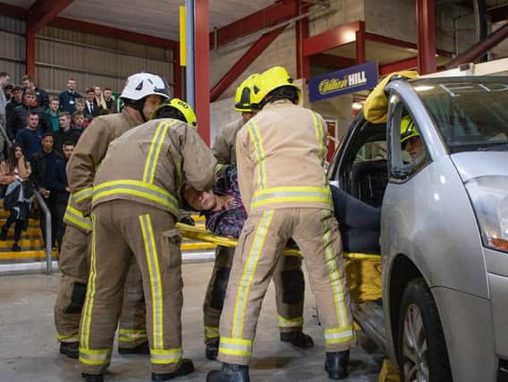 Bradford apprentice Freya Leader demonstrates a road traffic accident
rescue scenario and is lifted from a training vehicle by West Yorkshire Fire and
Rescue as part of the Bradford Manufacturing Weeks driver awareness event.
