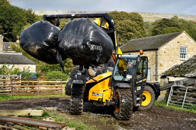 Some of the damaged bales being removed from a flood-hit farm in the Yorkshire Dales. Picture courtesy of JCB.
