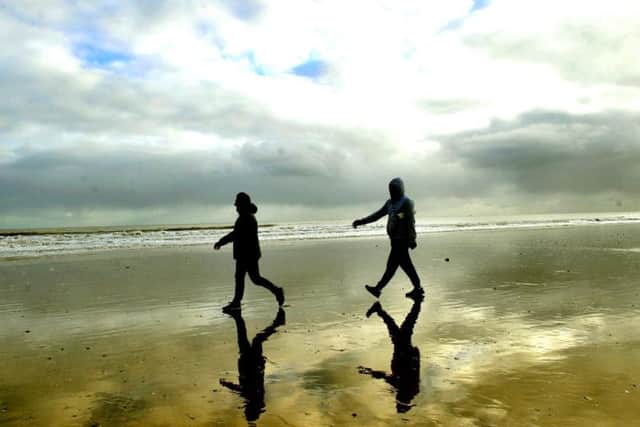 Two visitors to Bridlington South Beach are reflected in the North Sea Picture: Gary Longbottom
