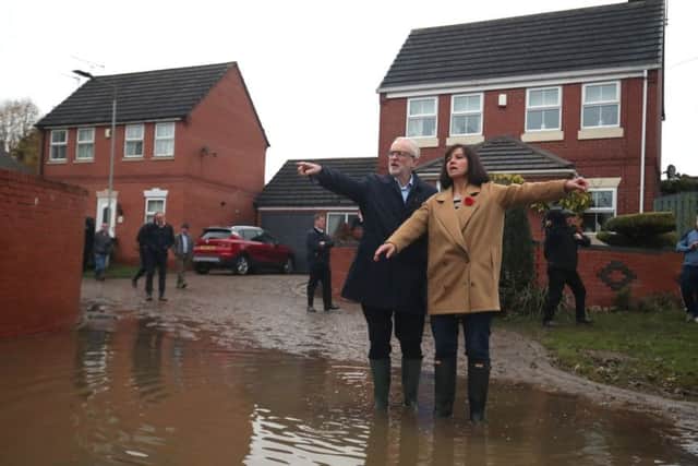 Labour leader Jeremy Corbyn with Labour MP Caroline Flint during a visit to Conisborough, South Yorkshire, where he met residents affected by flooding.