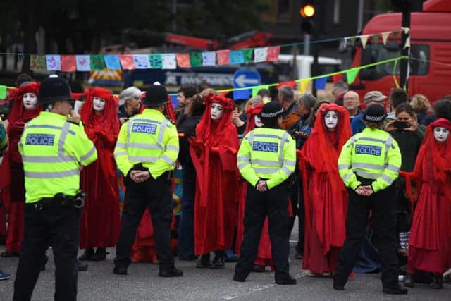 LONDON, ENGLAND - OCTOBER 07: Members of The Red Brigade of The Invisible Circus gesture to police by Lambeth Bridge on October 7, 2019 in London, England. Climate change activists are gathering to block access to various government departments as they start a two week protest in central London (Photo by Chris J Ratcliffe/Getty Images)