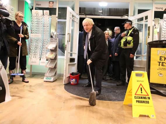 Boris Johnson helps with the clean up at an opticians in Matlock, Derbyshire, on November 8 after it was affected by flooding (Photo: Danny Lawson).
