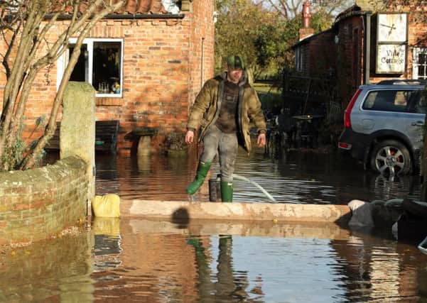 A man walks through floodwater near Fishlake in Doncaster.
