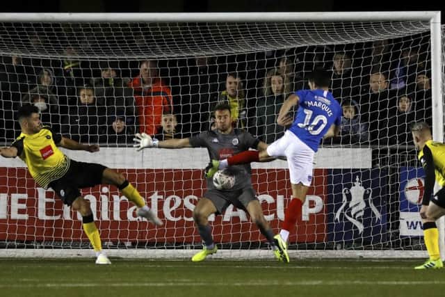 Portsmouth's John Marquis has a shot on goal saved by Harrogate Town goalkeeper James Belshaw (Picture: PA)