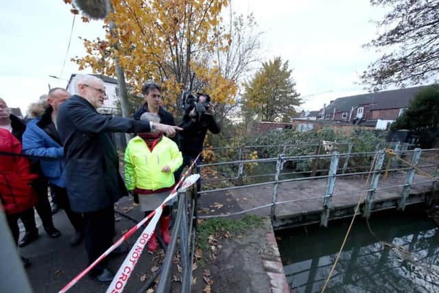 Labour Party leader Jeremy Corbyn (left) with former Labour leader Ed Milliband (right) are shown the water level in Bentley, Doncaster, South Yorkshire, during General Election campaigning. Pic: PA