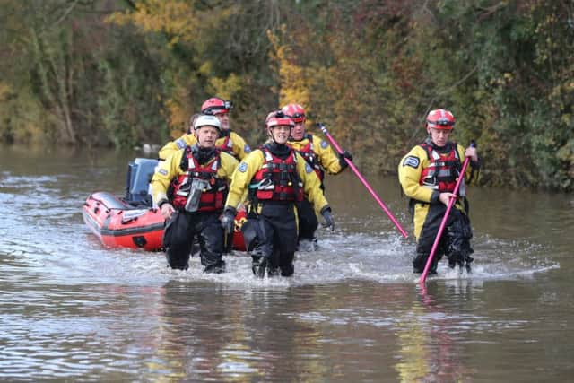 Rescuers pull a boat through floodwater in Fishlake, Doncaster.