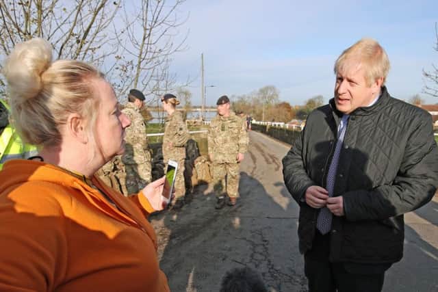 Prime Minister Boris Johnson talks to a woman during a visit to Stainforth, Doncaster, to see the recent flooding.