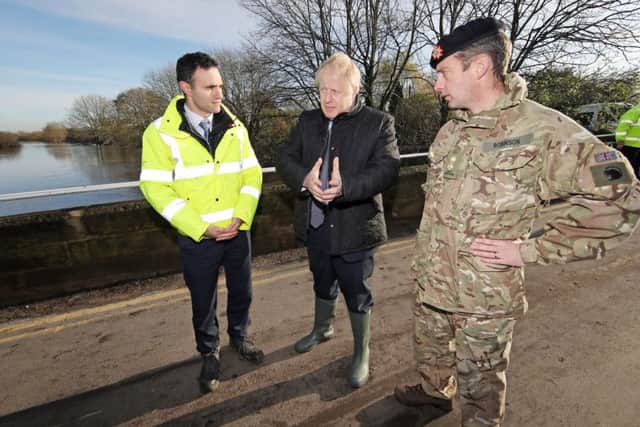 Prime Minister Boris Johnson walks with Lt Col Tom Robinson from the Light Dragoons and an Environment Agency official during a visit to Stainforth, Doncaster, to see this month's flooding damage.