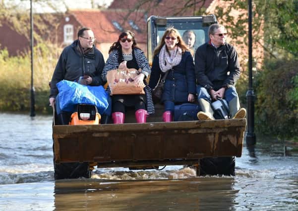 A JCB transports people and their belongings through floodwater to other parts of Fishlake, Doncaster. Picture: Ben Birchall/PA Wire