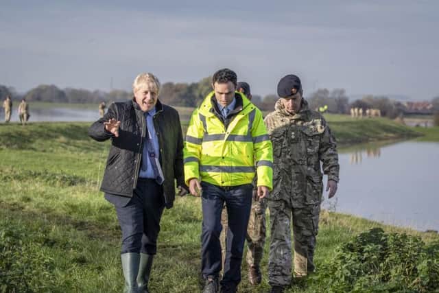 Prime Minister Boris Johnson walks with Lt Col Tom Robinson (right) from the Light Dragoons and Oliver Harmar (centre), the Yorkshire Area Director of the Environment Agency, during a visit to Stainforth, Doncaster, to see the recent flooding. Photo: Danny Lawson/PA Wire
