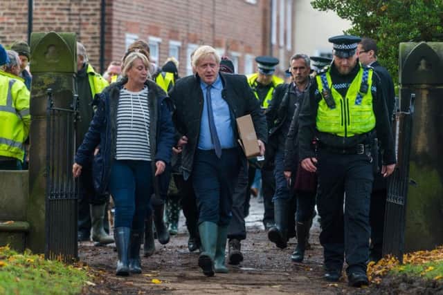 The Prime Minister Boris Johnson, arriving at St Cuthbert's Church, Fishlake, near Doncaster, before chatting with victims and volunteers of the floods, pictured walking with Pam Webb, from Truffle Lodge, Fishlake. Photo: PA