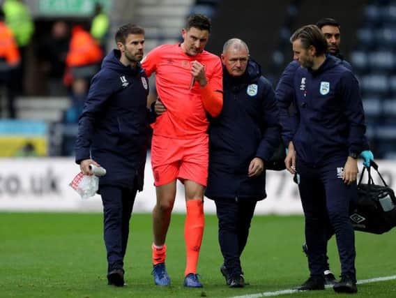 Huddersfield Town's Tommy Elphick is helped from the field after injuring his knee against Preston North End on Saturday