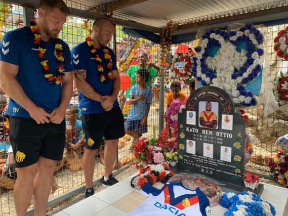 Great Britain's Elliott Whitehead, left, and Josh Hodgson visit the grave of former Canberra Raiders team-mate Kato Ottio in his home village in Papua New Guinea. (CREDIT: RFL)
