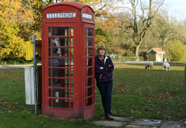 Parish Councillor Jayne Harker with the red phone box on Goathland village green. Picture: Jonathan Gawthorpe