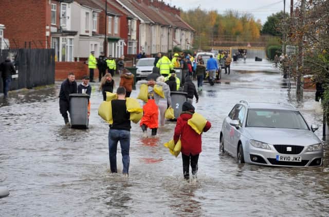 Residents using wheelie bins and wheel barrows to sandbag properties on Conyers Road on a flooded estate in Bentley, Doncaster on November 8, 2019.   Picture: Tony Johnson