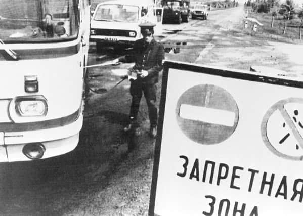 A policeman checks the level of radioactivity on vehicles leaving the 30 km forbidden area around Chernobyl after the nuclear plant No. 4 reactor's blast, 26 April 1986, the world's worst nuclear accident of the 20th century. (Photo credit: STF/AFP/Getty Images)