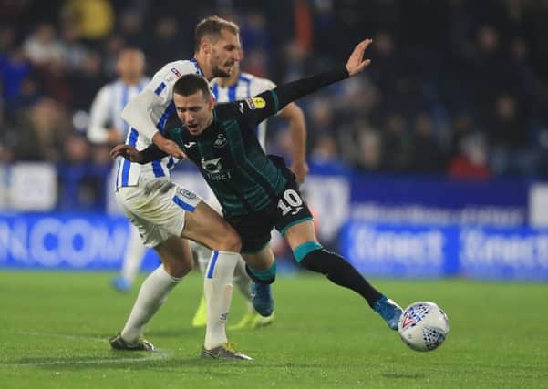 Battling for the cause: Huddersfield Town's Jon Gorenc Stankovic challenges Swansea City's Bersant Celina.