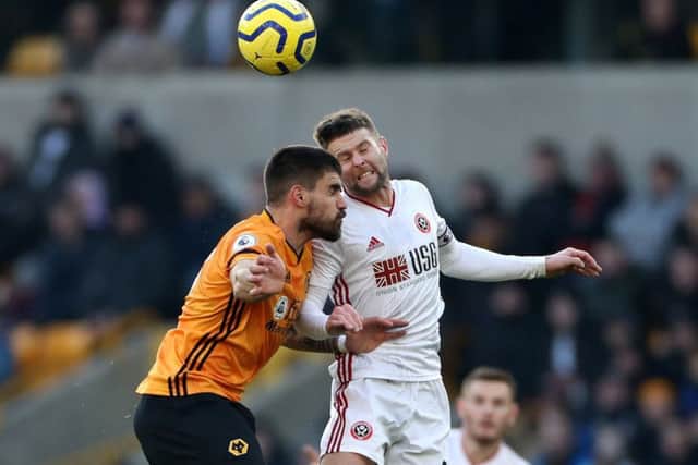 Oliver Norwood: Sheffield United midfielder, right, challenges Wolves Ruben Neves. (Picture: PA)