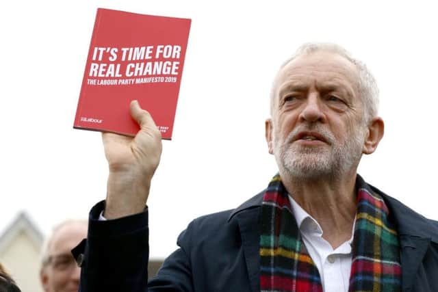 Labour Party leader Jeremy Corbyn, holds up his party's manifesto. Credit: Aaron Chown/PA Wire