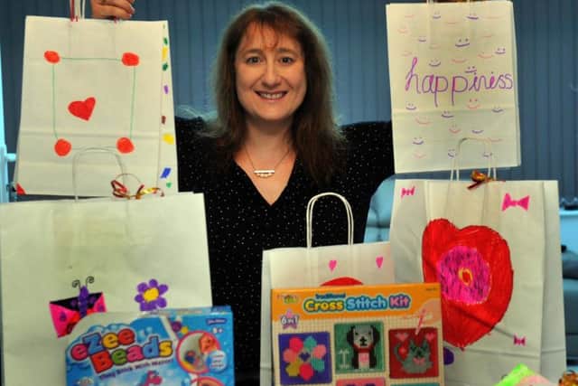 Claire Baskind, with some of the items donated as part of Christmas Gifts for Poorly Kids, which will go to children who find themselves staying in hospital this festive season. Image: Gary Longbottom.