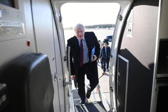 Prime Minister Boris Johnson boards his plane, following a visit to a Grimsby Fish Market, as he heads north to Teesside for the next stop on the General Election campaign trail. Photo: Stefan Rousseau/PA Wire