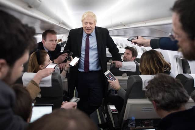 Prime Minister Boris Johnson speaks to the press on board his campaign plane this week.