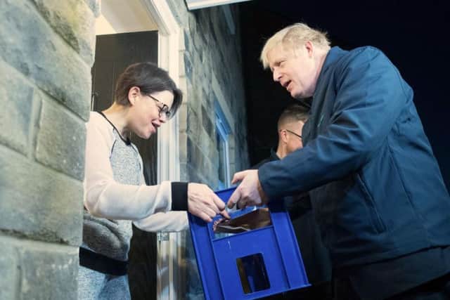 Boris Johnson delivers milk to Debbie Monaghan in Guiseley. Photo: PA