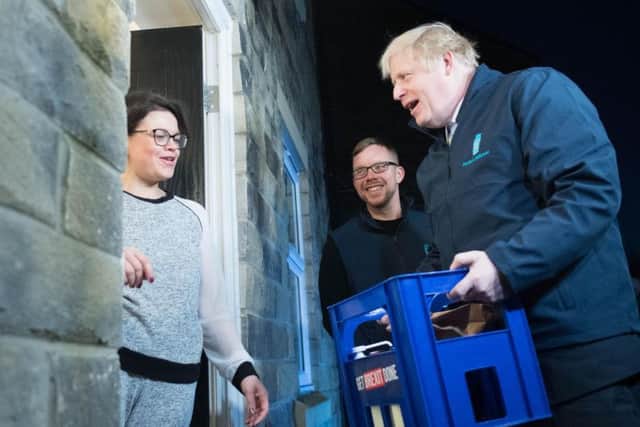 Boris Johnson delivers milk to Debbie Monaghan in Guiseley. Photo: PA