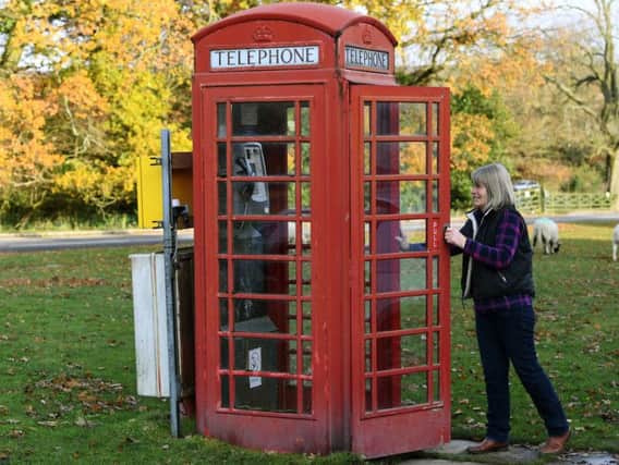 Parish Councillor Jayne Harker with a working red phone box on Goathland Village Green. Picture: Jonathan Gawthorpe.